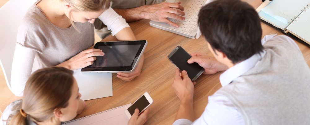 Group of business people using electronic devices at work